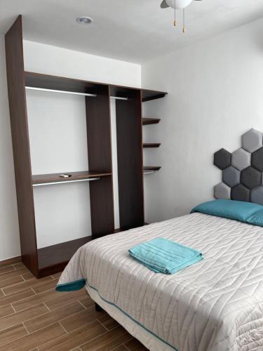 a bedroom with a large bed with a wooden floor at Departamento Bohen 13 in Mérida