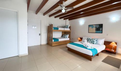 a bedroom with two beds and a ceiling fan at Hostería del Parque in Machalilla