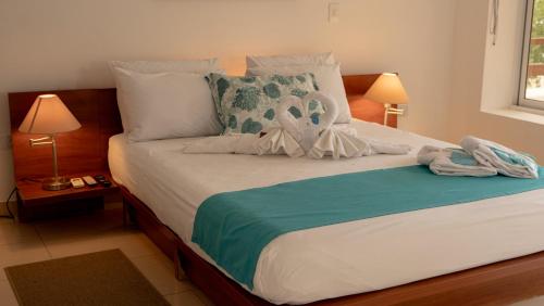 a bedroom with a bed with towels on it at Hostería del Parque in Machalilla