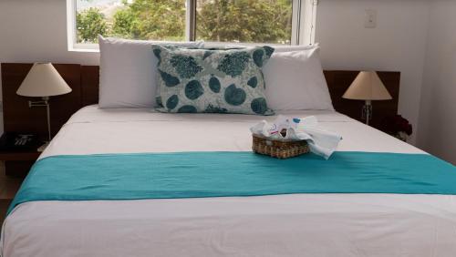 a bedroom with a bed with a basket on it at Hostería del Parque in Machalilla