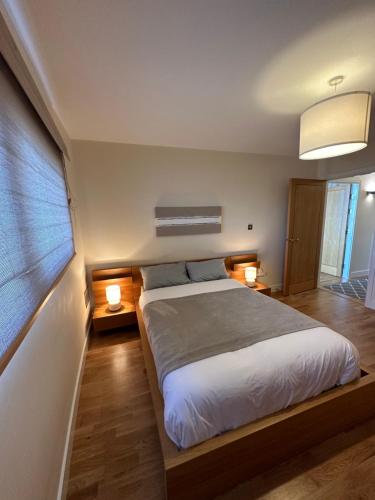 una camera con un grande letto con due lampade di Cardiff City Center - with Parking a Cardiff