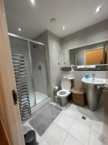 a bathroom with a shower and a toilet and a sink at Cardiff City Center - with FREE Parking in Cardiff