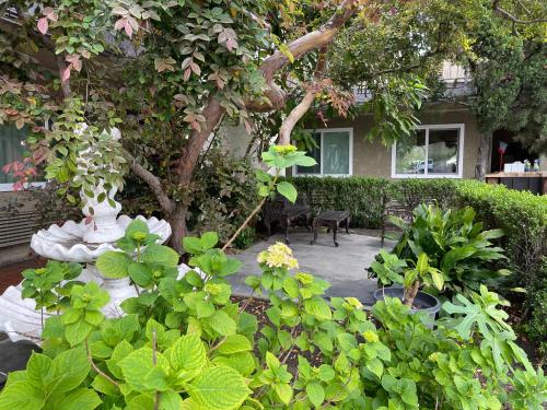 a garden with a vase and plants in front of a house at Quality Inn Ontario Airport Convention Center in Ontario