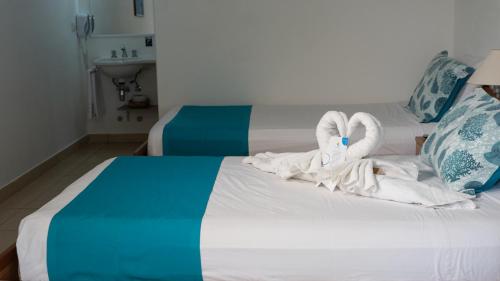 a hotel room with towels on a bed at Hostería del Parque in Machalilla