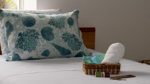 a basket of towels and a pillow on a bed at Hostería del Parque in Machalilla