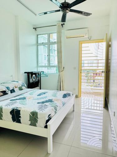 a white bedroom with a bed and a window at Spice Arena Service Apartment in Bayan Lepas