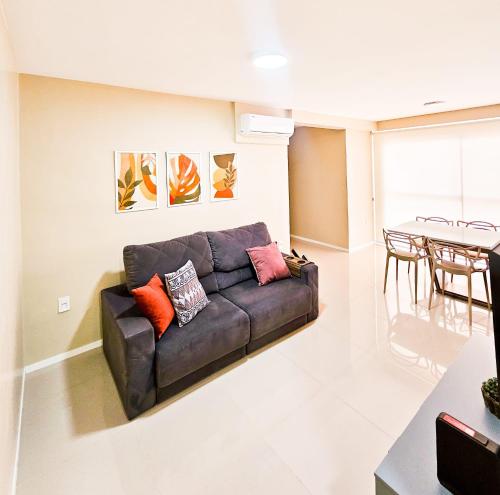 - un salon avec un canapé et une table dans l'établissement Apartamento 3 quartos - Setor Coimbra, à Goiânia