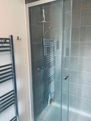 y baño con ducha y puerta de cristal. en Riverside Apartment, en Northampton