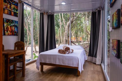 1 dormitorio con cama y ventana grande en Jungle house with a pool en Akumal