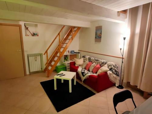 a living room with a red couch and a staircase at Stefy House in Lastra a Signa
