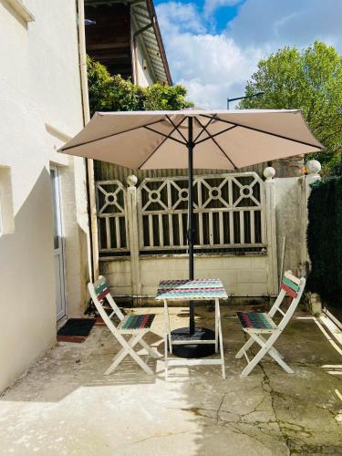 a table and two chairs and an umbrella at Studio house near paris in Épinay-sur-Seine