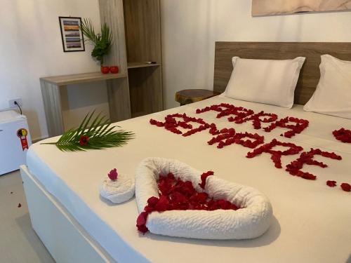 a bed with a heart made out of red roses at Pousada Águas de Tamandaré in Tamandaré