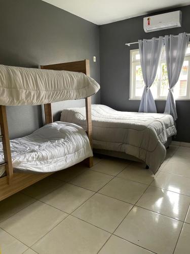 a bedroom with two bunk beds and a window at Hospedagem Dona Ester in Pomerode