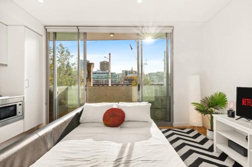 a living room with a couch with a basketball on it at Central, modern 1 bedroom with air-con & balcony in Sydney