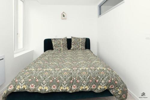 - une chambre dotée d'un lit avec une couverture et des oreillers dans l'établissement La résidence Jeanne d'Arc 3, Troyes, à Troyes
