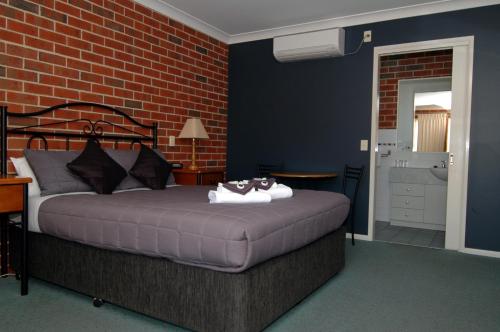 Un dormitorio con una cama con dos animales de peluche encima. en Poachers Paradise, en Rutherglen