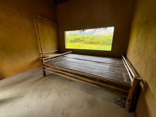 Habitación pequeña con cama y ventana en Home 89 - Homestay & Retreat en Trai Ðỏ