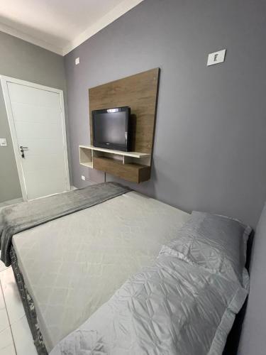 馬林加的住宿－Kitnet Luz do Mar，一间卧室配有一张床和一台平面电视
