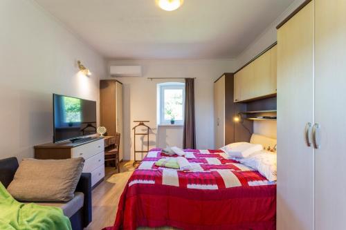 1 dormitorio con 1 cama con manta roja y blanca en Holiday house with a swimming pool Vinez, Labin - 22240, en Vinež