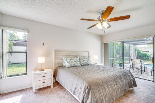 a bedroom with a bed and a ceiling fan at Fort Myers Home, Lanai and Private, Heated Pool in Fort Myers