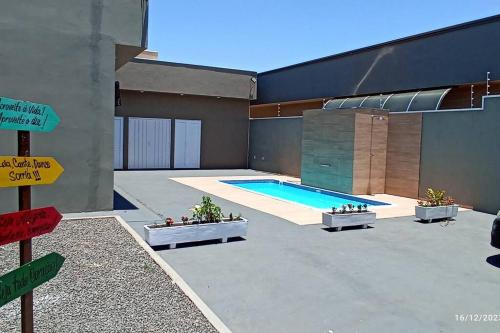 a building with a swimming pool next to a building at Recanto Matheus Casa de Temporada Olímpia SP in Olímpia