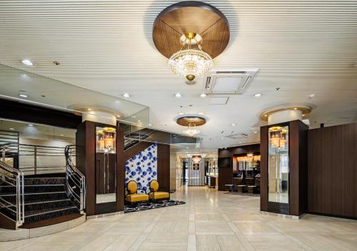 a lobby with a chandelier and stairs in a building at APA Hotel Kokura Ekimae in Kitakyushu