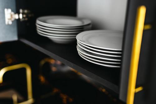 a stack of plates sitting on a shelf at Modern Lux Apartment 3 in Brčko