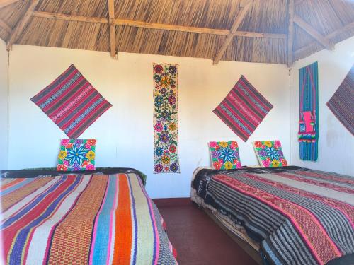 a room with two beds in a room at Hanan Pacha Lodge in Puno
