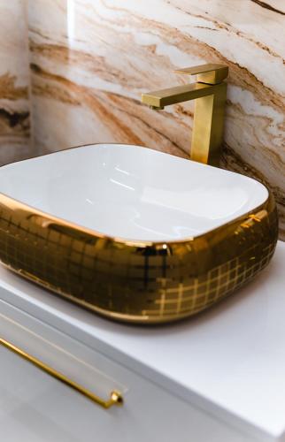 a gold bathroom sink with a gold faucet at Modern Lux Apartment 3 in Brčko