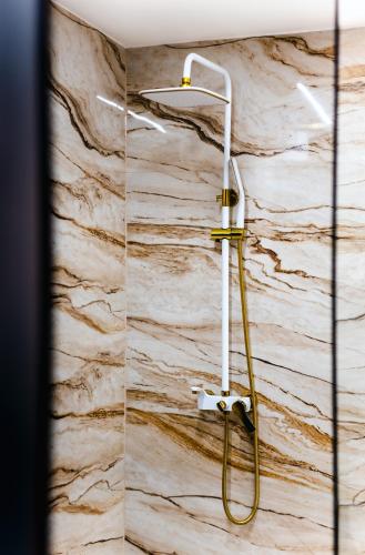 a shower with a hose on a marble wall at Modern Lux Apartment 3 in Brčko