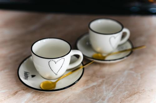 two coffee cups sitting on saucers on a table at Modern Lux Apartment 3 in Brčko