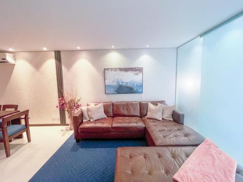 sala de estar con sofá marrón y mesa en Luxurious stay at modern apartment (Equipetrol), en Santa Cruz de la Sierra