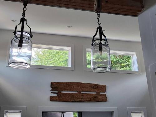 two lights hanging from the ceiling in a kitchen at Tiny House with HOT TUB, close to golf and hiking!! in Oyster Bay