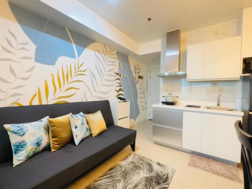 ein Wohnzimmer mit einem Sofa und einer Küche in der Unterkunft Lovely and Refreshing 1BR Suite in Manila