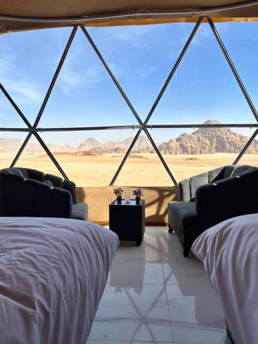 a room with beds and a view of the desert at Nara desert camp in Wadi Rum
