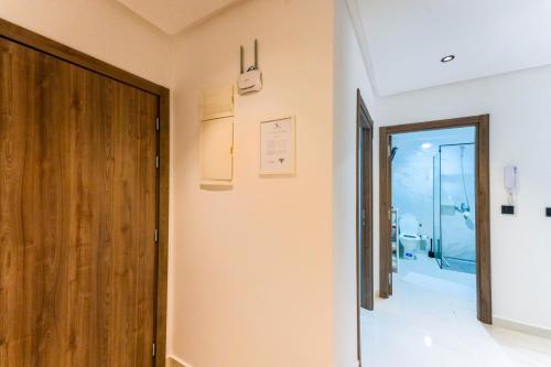 a hallway with a wooden door and a bathroom at Résidences & Suites Nador in Nador
