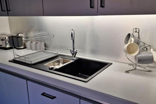 a kitchen counter top with a sink and a sink at Modern 1 Bed Apartment With Secure Gated Parking in Bradford