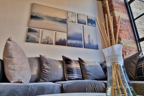 a couch in a living room with pictures on the wall at Modern 1 Bed Apartment With Secure Gated Parking in Bradford