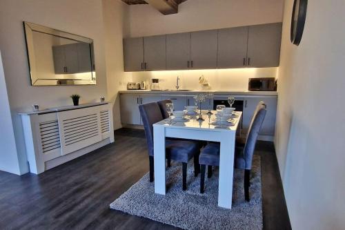 a kitchen with a white dining table and chairs at Modern 1 Bed Apartment With Secure Gated Parking in Bradford