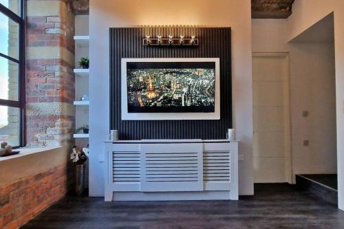a living room with a tv on a wall at Modern 1 Bed Apartment With Secure Gated Parking in Bradford