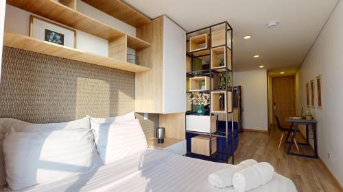 sypialnia z dużym łóżkiem z białymi poduszkami w obiekcie Apartasuites Cabrera 85 w mieście Bogota
