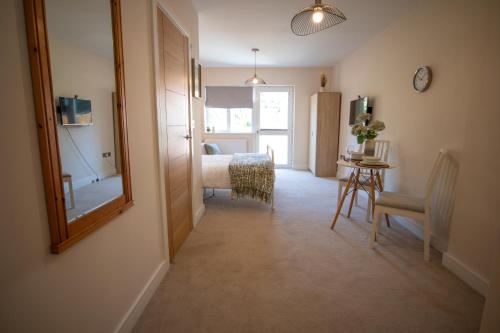 a bedroom with a bed and a mirror and a table at Tranquility Short & Long stays in Eastbourne