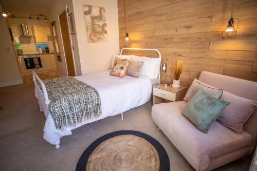 a bedroom with a large bed and a couch at Tranquility Short & Long stays in Eastbourne