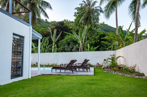 a backyard with two chairs and a pool at Secret Pearls by Matira Beach in Bora Bora