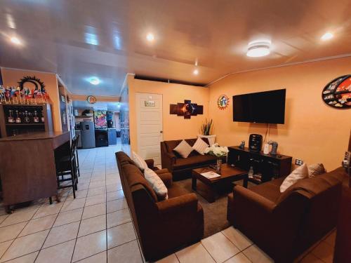 a living room with couches and a flat screen tv at Hostal Sol y Luna 