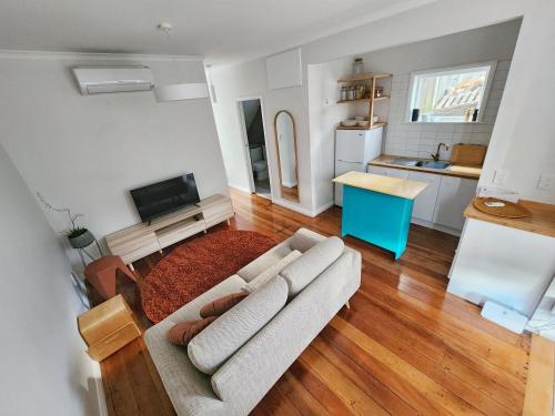 a living room with a couch and a kitchen at City Edge Nest in Wellington