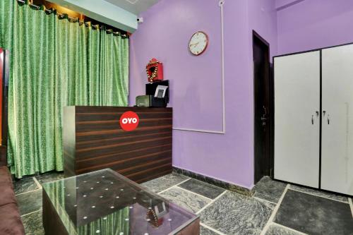 勒克瑙的住宿－Collection O Hotel RBS，一间紫色墙壁的房间和墙上的时钟