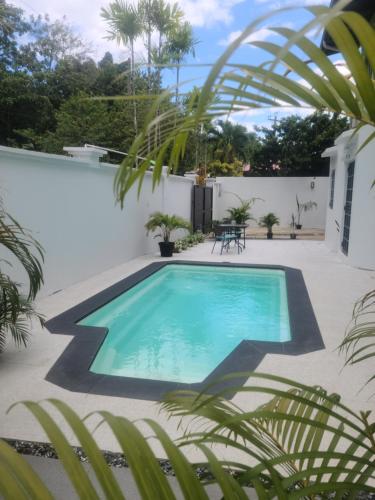 een zwembad in het midden van een tuin bij Riverside Apartments in San Juan