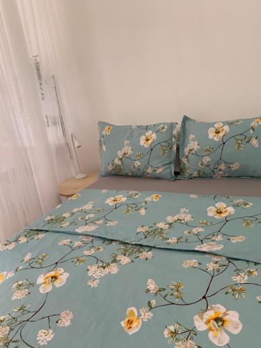 a bed with a blue comforter with flowers on it at Hummingbird's Retreat-One bedroom-private bath-private entry door in Las Vegas