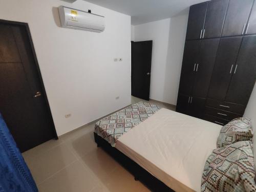 - une petite chambre avec un lit et des placards dans l'établissement Oceano, à Apartadó